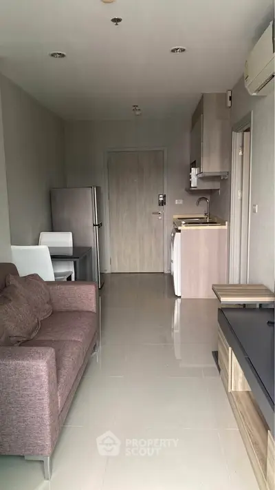 Modern apartment interior with compact kitchen and cozy living area, ideal for urban living.