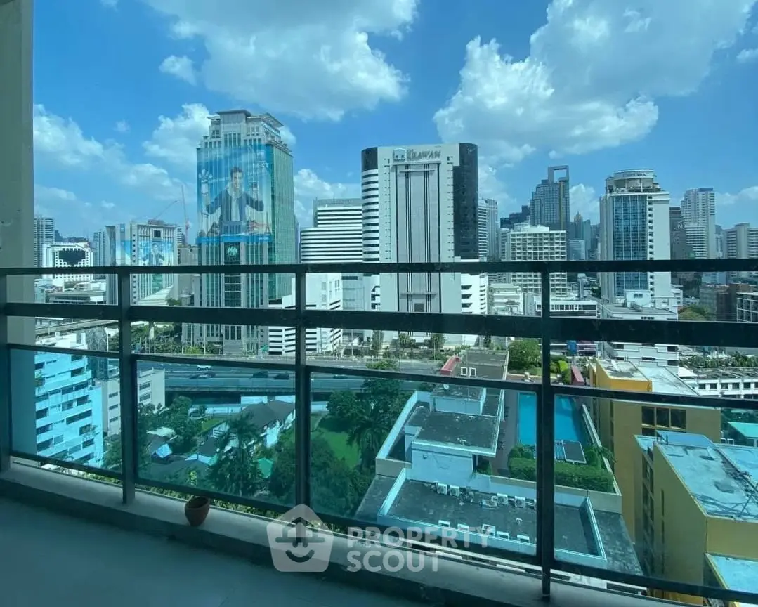 Stunning cityscape view from a high-rise balcony with clear blue skies.