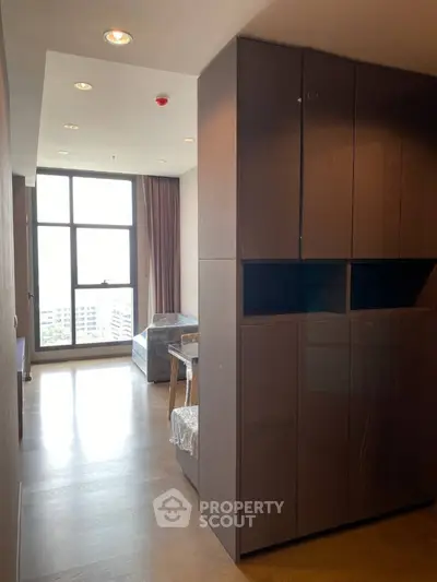 Modern apartment interior with large windows and wooden flooring, offering a bright and spacious living area.
