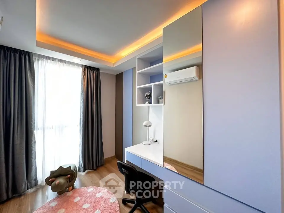 Modern study room with sleek desk, built-in shelves, and ambient lighting in a stylish apartment.