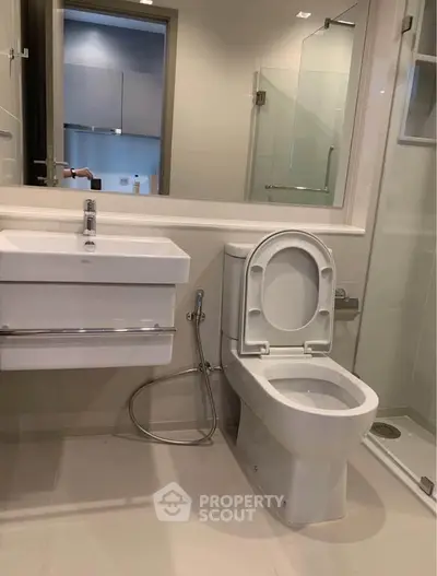 Modern bathroom with sleek fixtures and glass shower enclosure in a contemporary apartment.