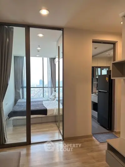 Modern apartment interior with glass-walled bedroom and city view, featuring sleek design and natural light.