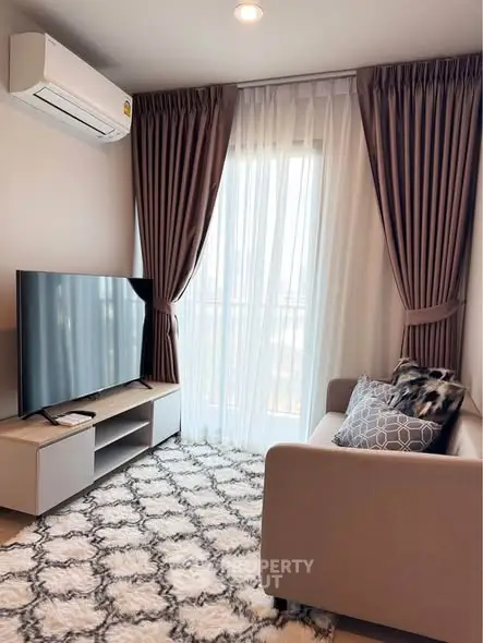 Cozy living room with modern decor, featuring a plush sofa, stylish rug, and large TV, perfect for relaxation.