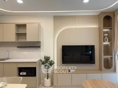 Modern living room with integrated kitchen, sleek cabinetry, and stylish decor.