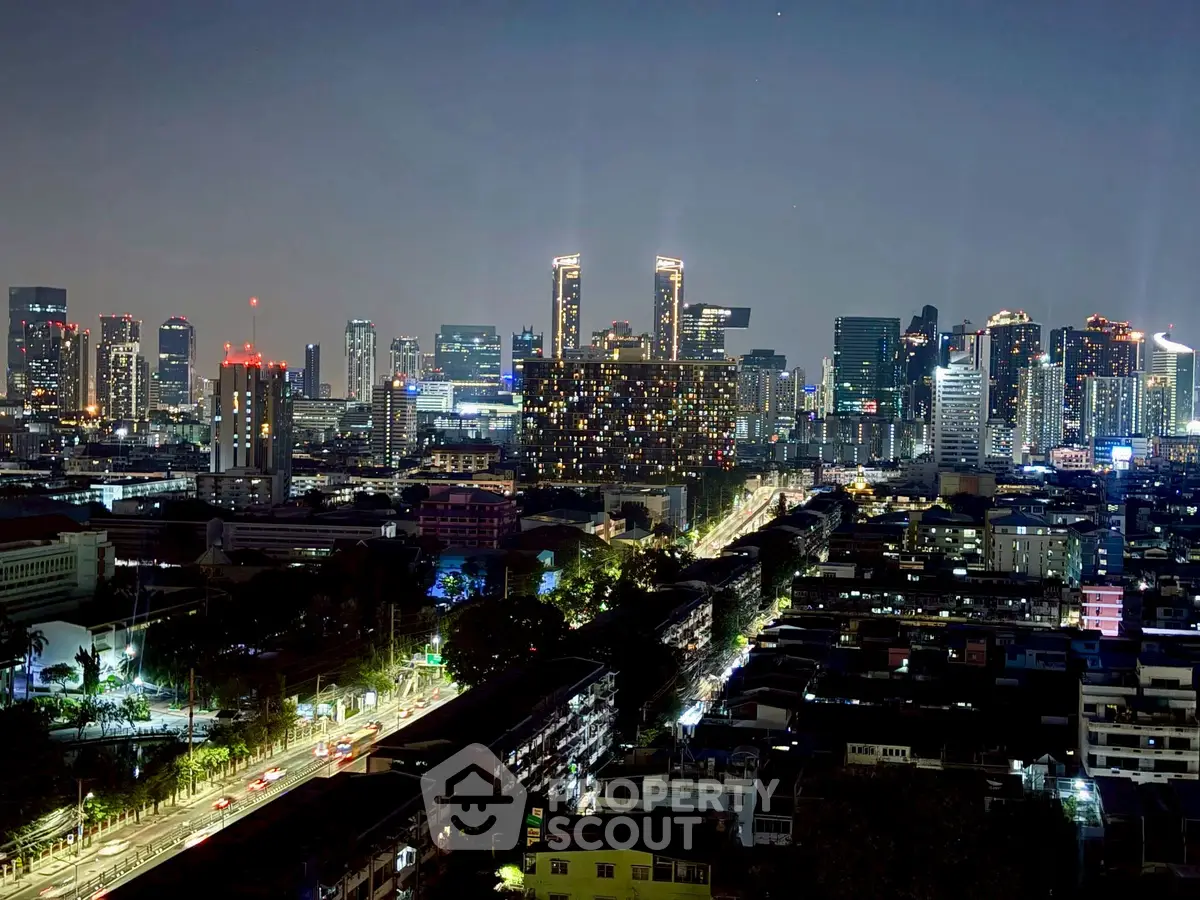 Stunning cityscape view from a high-rise building at night, showcasing vibrant city lights and skyline.