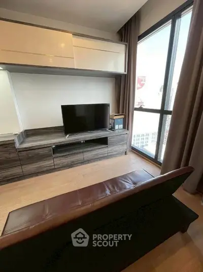 Modern living room with sleek TV unit and large window view.