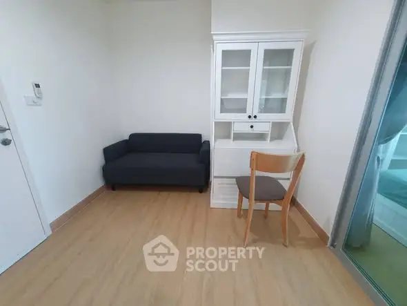 Cozy minimalist room with sofa, chair, and glass cabinet