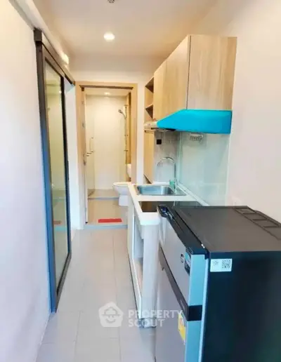 Compact kitchen with modern appliances and sleek design in a cozy apartment.