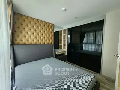 Modern bedroom with stylish headboard and mirrored wardrobe in a cozy apartment.