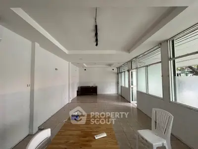 Spacious interior with tiled flooring and large windows, ideal for versatile use.