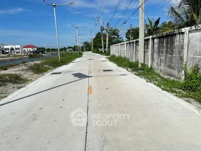Scenic road view with clear skies and lush greenery, perfect for real estate development.