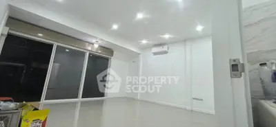 Spacious modern living room with bright lighting and large windows