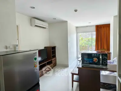 Modern living room with air conditioning, TV, and microwave, featuring a bright balcony view.