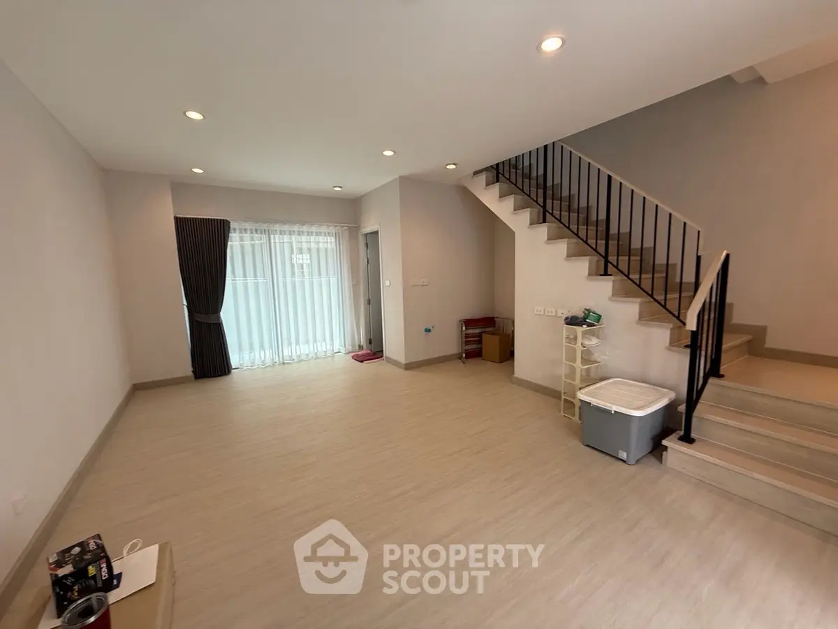 Spacious modern living room with staircase and natural light