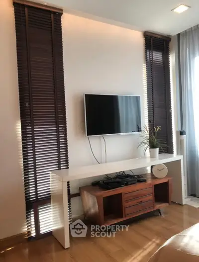 Modern living room with sleek TV setup and stylish wooden blinds