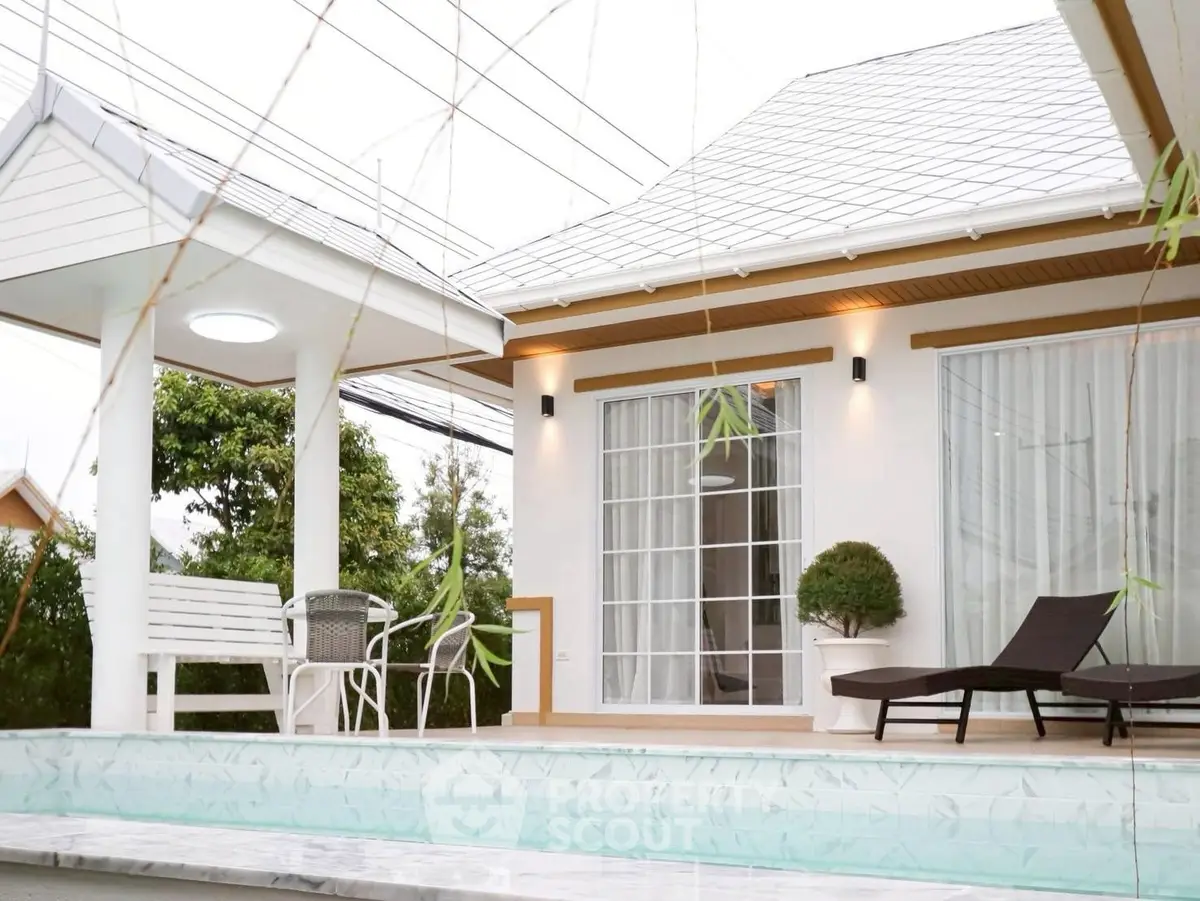 Charming modern house with poolside patio and elegant outdoor seating.