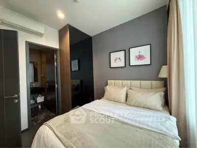 Cozy bedroom with modern decor and ensuite bathroom in stylish apartment.