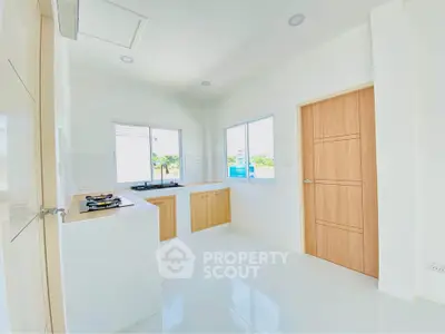 Bright modern kitchen with sleek white cabinets and large windows