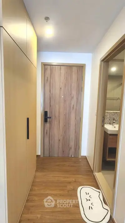 Modern apartment entrance with wooden flooring and stylish bathroom view