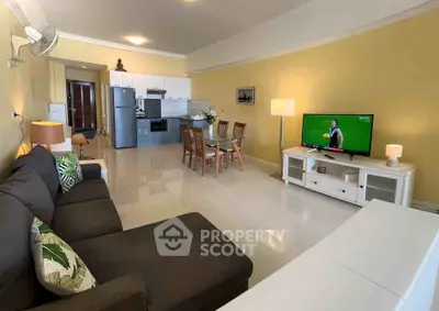 Spacious living room with modern kitchen, cozy sofa, and dining area, perfect for entertaining.