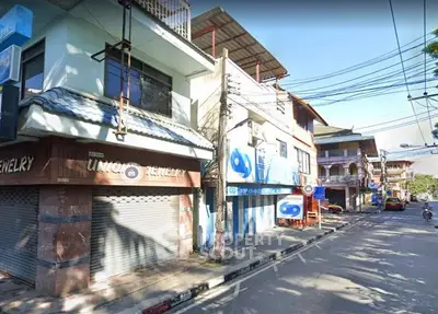Charming street view of commercial buildings with unique architectural features in a bustling neighborhood.