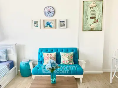 Charming living room with vibrant blue sofa and decorative wall art