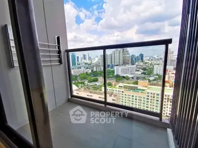Stunning city view from a modern high-rise balcony with glass railing.