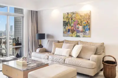 Elegant living room with plush sofa, modern decor, and city view balcony, perfect for urban living.