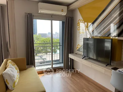 Modern living room with balcony and city view, featuring stylish decor and natural light.