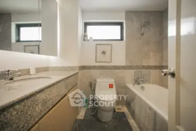 Modern bathroom with sleek design and bathtub in a stylish real estate property.