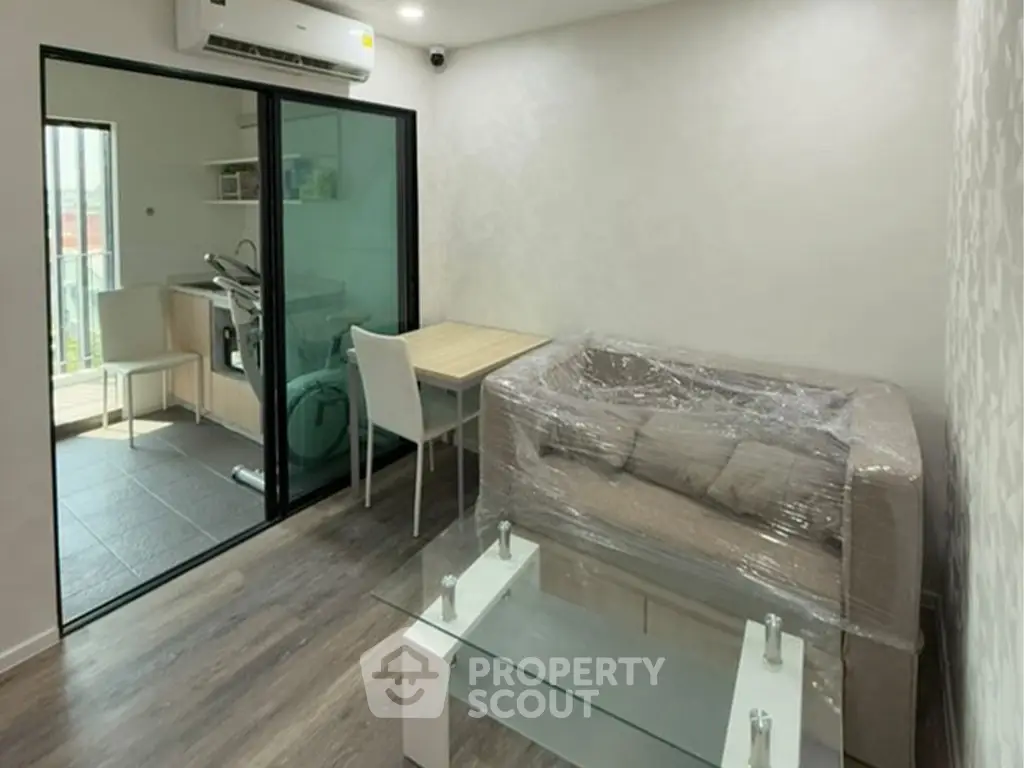 Modern living room with glass coffee table and compact kitchen area