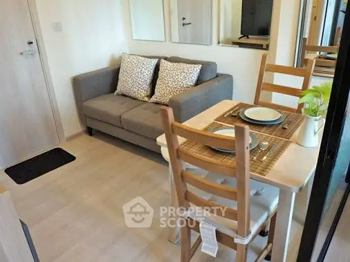 Cozy living room with dining area in modern apartment, featuring a comfortable sofa and stylish dining set.
