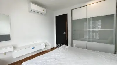Modern bedroom with sleek design, featuring built-in wardrobe and air conditioning, perfect for urban living.