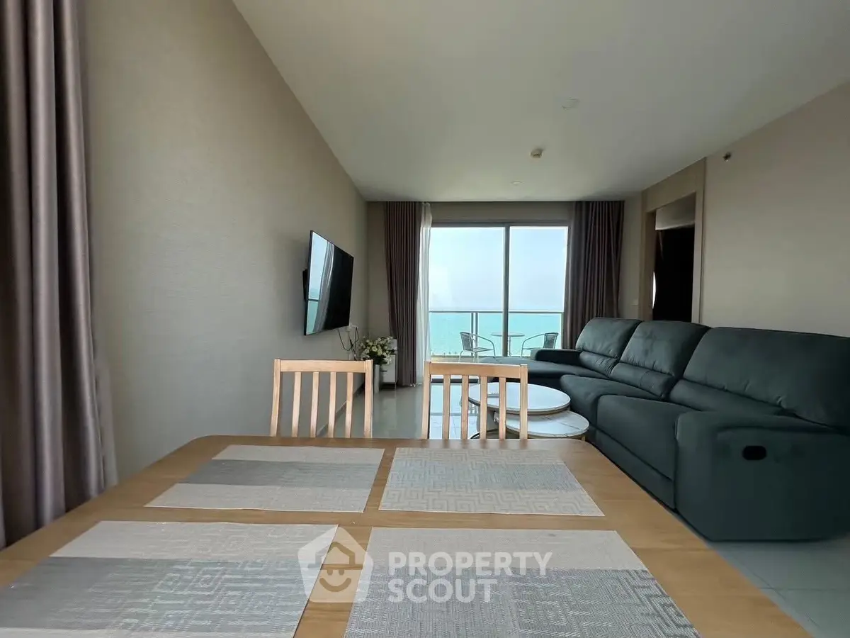 Spacious living room with ocean view, modern furniture, and elegant decor.