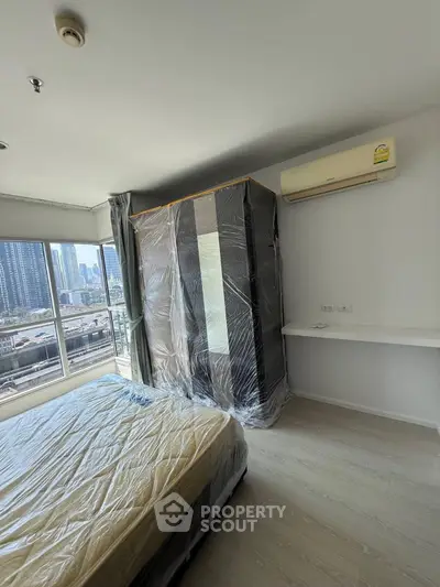 Modern bedroom with city view, featuring air conditioning and sleek furniture.