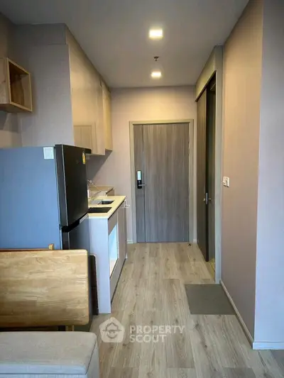 Modern compact kitchen with sleek appliances and wood flooring
