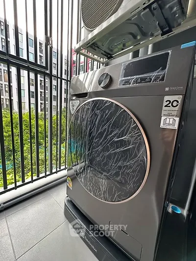Modern washing machine on a balcony with city view, perfect for urban living convenience.