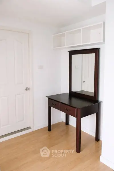 Elegant wooden vanity with mirror in a bright room, showcasing minimalist design and ample storage.