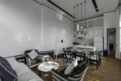 Elegant open-plan living room and kitchen with modern decor and high ceilings