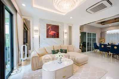 Luxurious living room with elegant decor and modern furnishings, featuring a stylish chandelier and large windows.