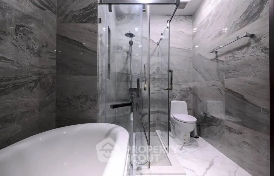 Luxurious modern bathroom with marble walls and glass shower enclosure