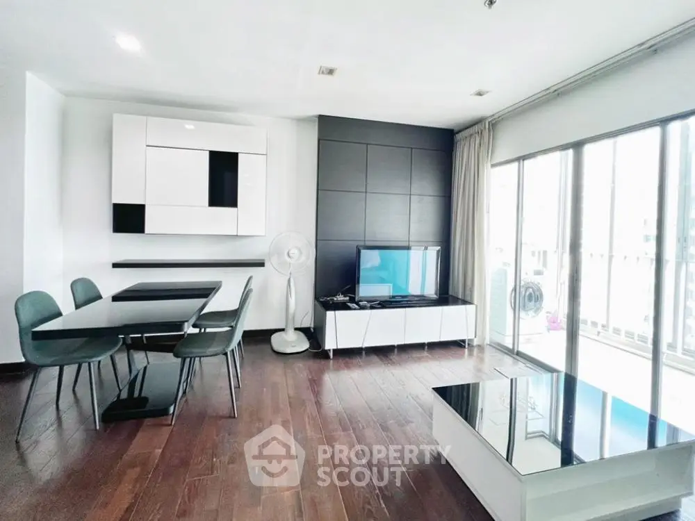 Modern living room with sleek furniture and large windows offering natural light