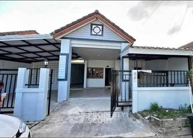 Charming single-story house with gated entrance and carport in a serene neighborhood.