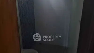 Compact bathroom with tiled walls and floor, featuring a toilet and shower area.