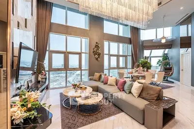 Luxurious high-ceiling living room with panoramic city views and elegant decor.