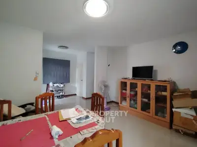 Spacious living room with dining area and modern furnishings in a cozy apartment.
