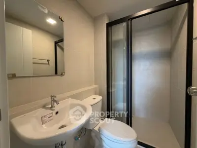 Modern bathroom with glass shower and sleek fixtures in contemporary apartment.