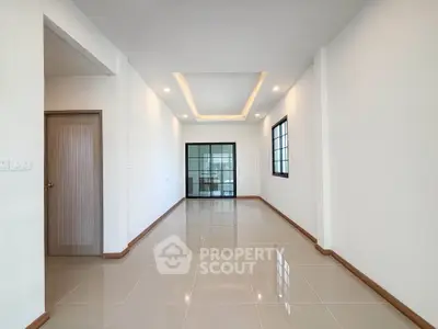 Spacious modern living room with sleek tile flooring and recessed lighting, perfect for stylish living.