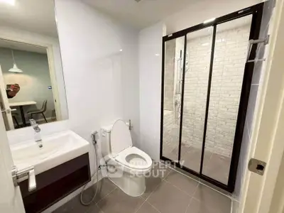 Modern bathroom with glass shower and sleek fixtures in a contemporary apartment.