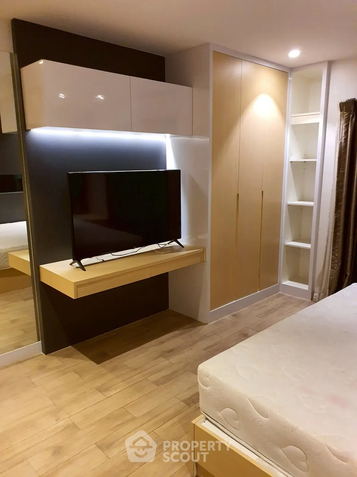 Modern bedroom with sleek TV setup and ample storage space